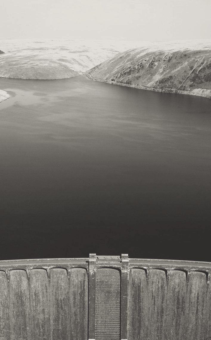 A dam wall holding back a reservoir, seen from above